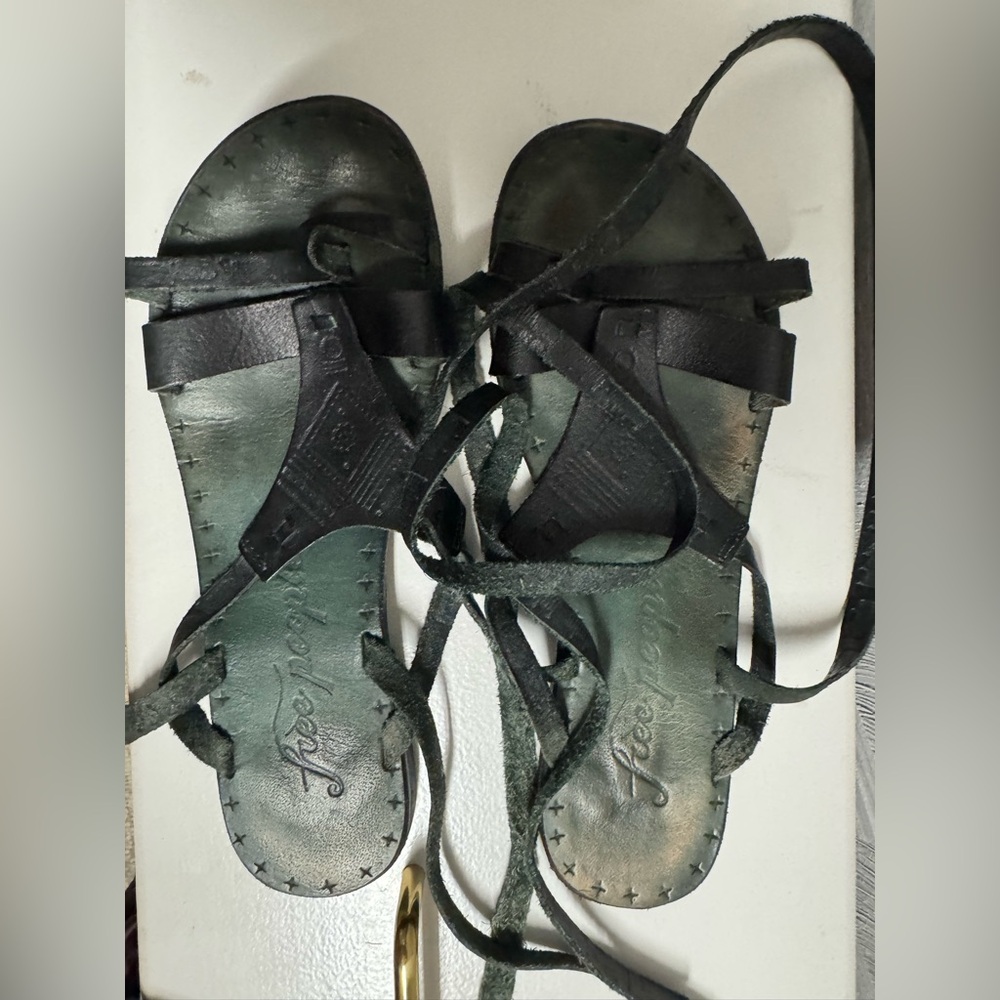 Ladies black Free People leather wrap around ankle sandals.